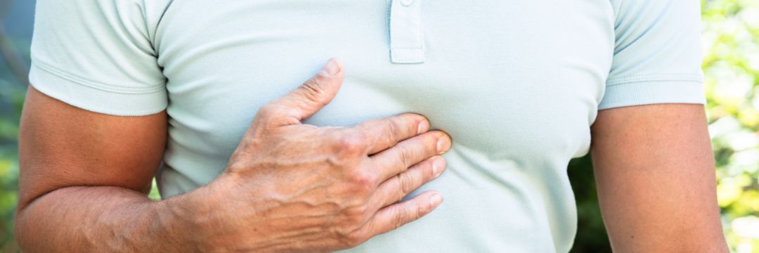 Man experiencing reflux symptoms touching chest 