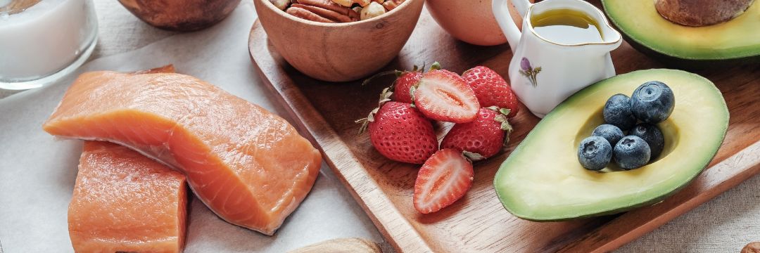 Array of healthy, nutritious food on wooden tray and counter top 