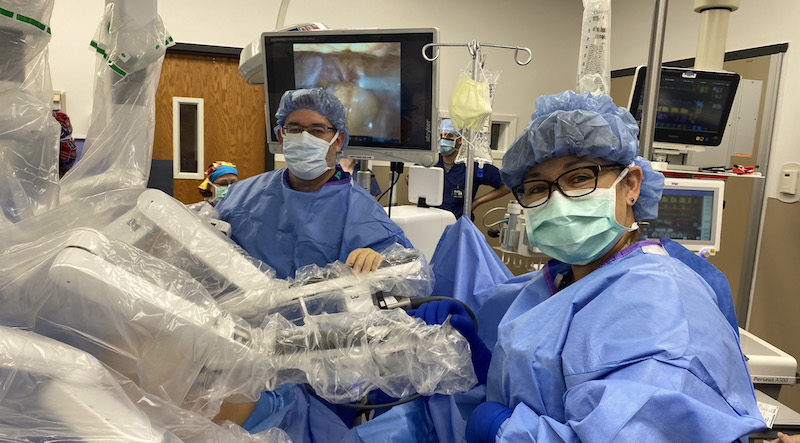 Dr. Higa In The OR with The Surgical Robot
