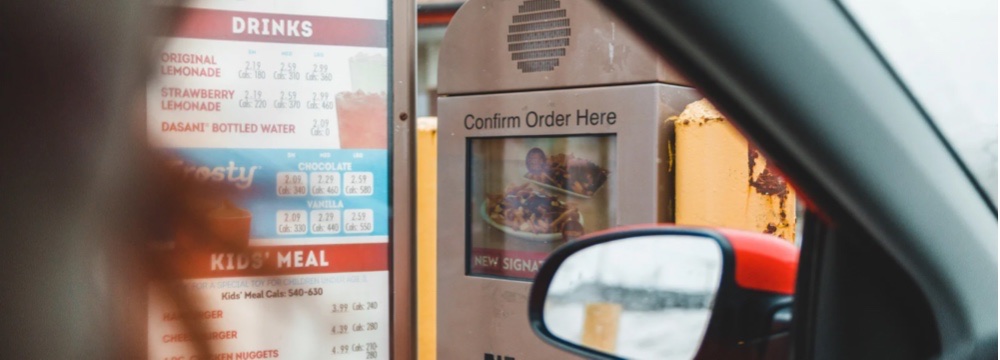 Woman sits in drive through line contemplating her healthiest fast food option in a pinch after bariatric surgery 