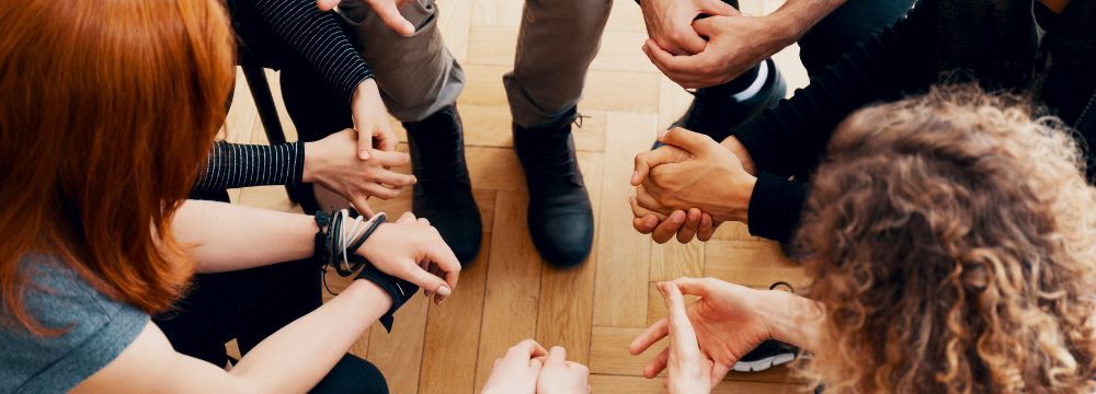 Support group circle discussing bariatric surgery, close up image of people's hands inside the circle