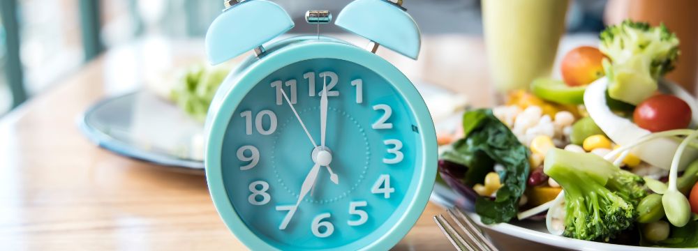 Clock on dining table next to salad